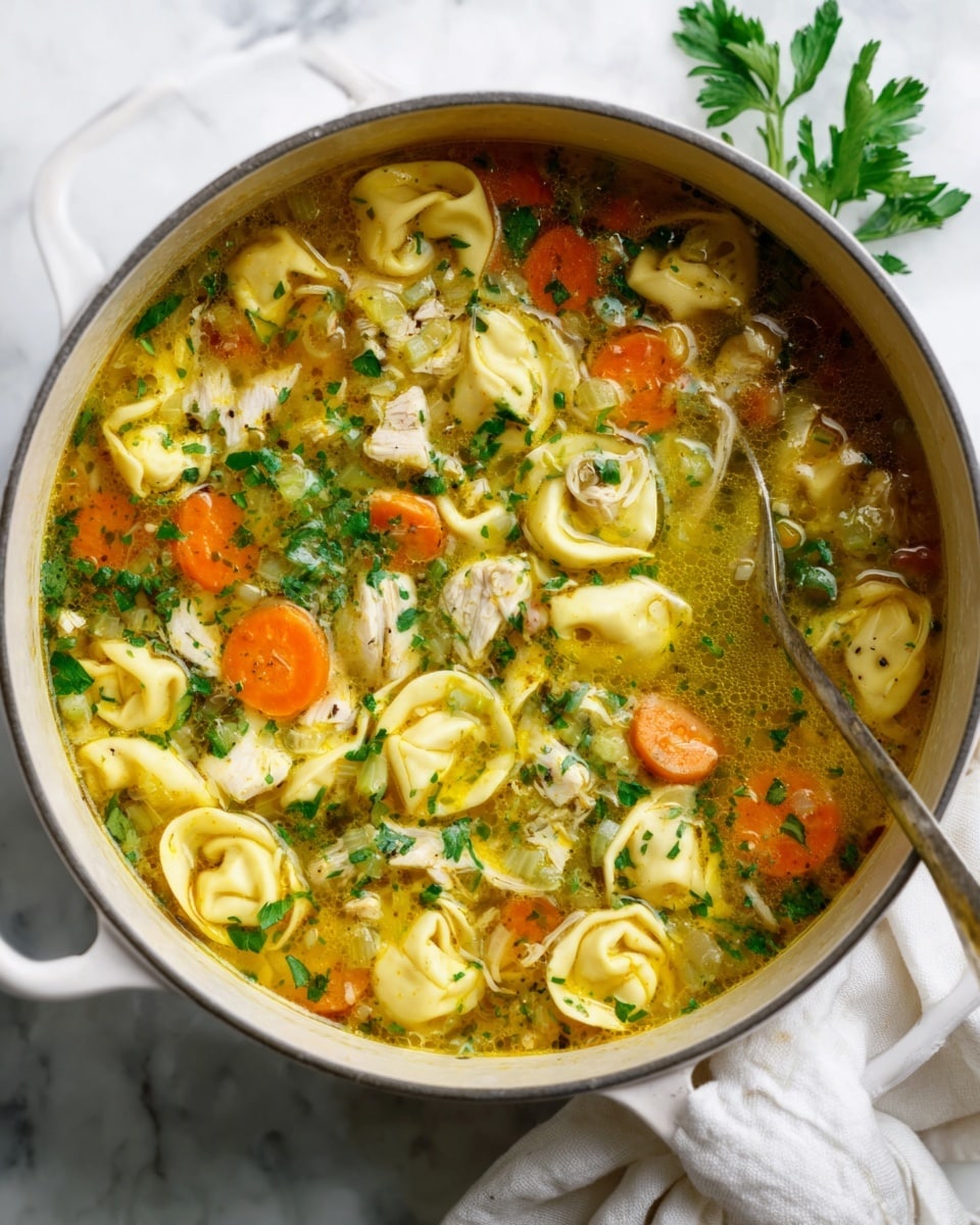 A white pot filled with a clear broth soup containing several layers of ingredients: the bottom layer is a mix of small, round pasta shells and diced orange carrots, above it are chunks of cooked chicken and bright green herbs sprinkled on top along with small pieces of celery and onions, all floating in the golden soup liquid. The pot’s handles are visible, and it rests on a white marbled surface with a white cloth partially tucked underneath. Photo taken with an iphone --ar 4:5 --v 7