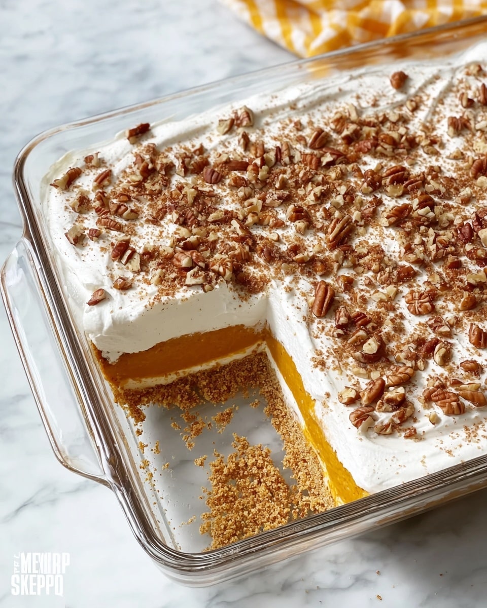 The dish is a layered dessert in a clear glass rectangular dish placed on a white marbled texture. It has three visible layers: the bottom layer is a golden brown crumb crust, the middle layer is a smooth orange pumpkin filling, and the top layer is a thick white whipped cream spread evenly across the surface. The whipped cream is sprinkled with chopped pecans covering the entire top. A rectangular portion has been cut out from the center, showing the layers clearly, with crumbs scattered inside the empty space. Photo taken with an iphone --ar 4:5 --v 7