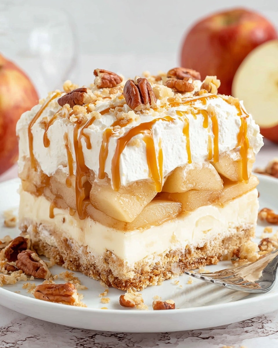 A square slice of layered dessert on a white plate shows four distinct layers: a bottom crumbly light brown crust, a thick creamy white layer above it, a middle layer of tender, light golden cooked apple slices with a syrupy glaze, and a top fluffy white cream layer. The dessert is decorated with drizzles of caramel sauce in a wavy pattern and sprinkled with small pieces of toasted pecans. Some crumbs and caramel have spilled onto the plate, and a silver fork rests nearby. The background has a soft white marbled texture with whole and sliced apples slightly blurred. Photo taken with an iphone --ar 4:5 --v 7